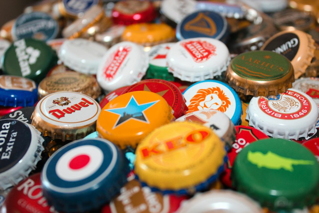 A vibrant assortment of beer bottle caps showcasing various brands and colors.